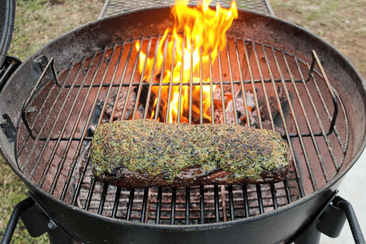 A beef tenderloin cooking on the grill indirectly. 