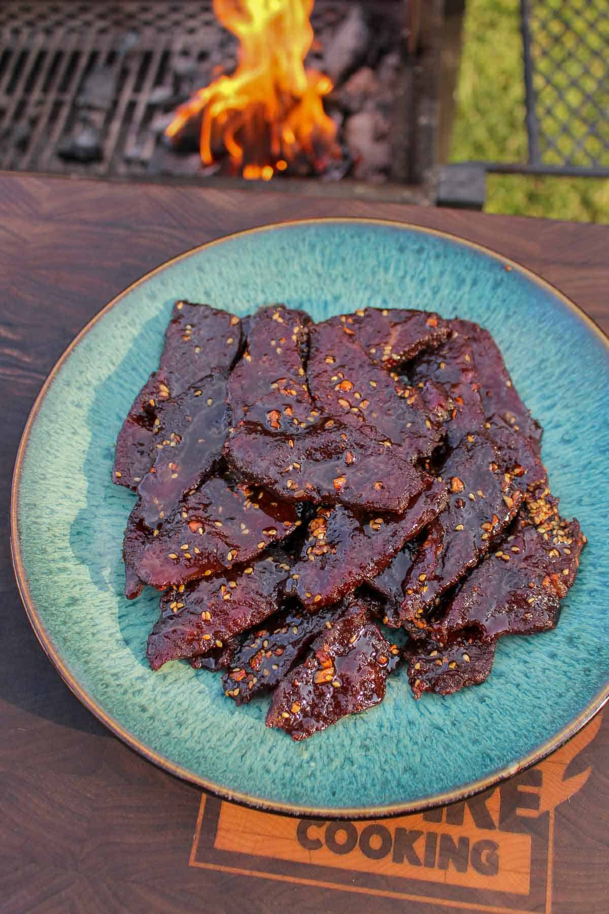 A pile of jerky stacked on a plate.