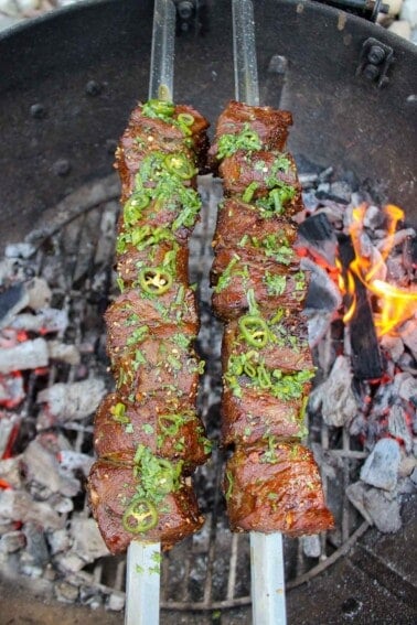 Black Pepper Steak Skewers finishing up their cooking process over the fire.
