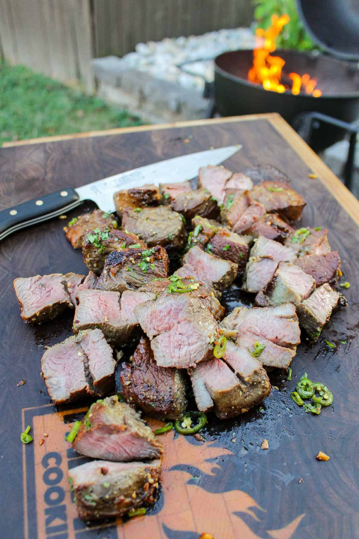 The sliced steak on a cutting board.