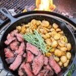The Grilled Steak with Skillet Potatoes served in a cast iron pan.