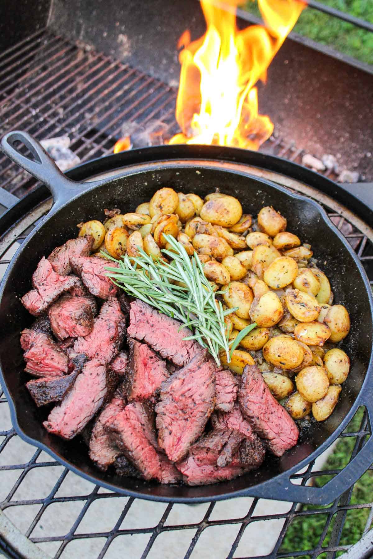 The Grilled Steak with Skillet Potatoes served in a cast iron pan.
