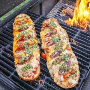 The two chorizo pizza breads next to each other on the grill.