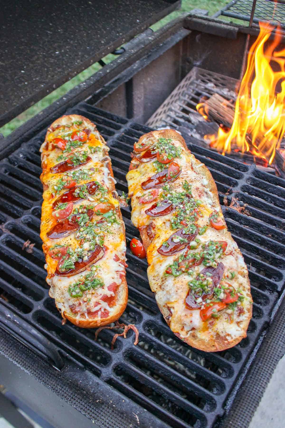 The two chorizo pizza breads next to each other on the grill.