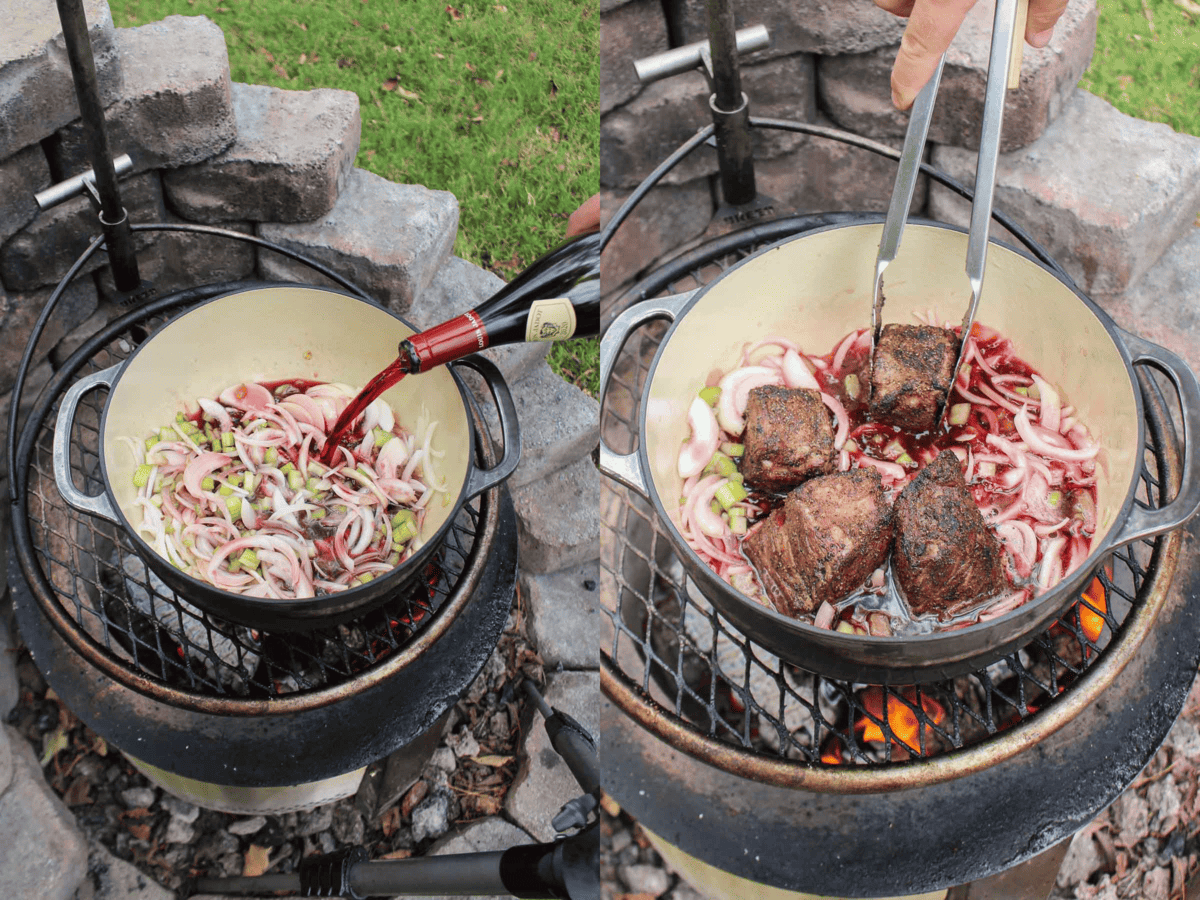 The braised beef ribs are placed back into the Dutch oven with the garlic, onions, celery, bay leaves, and red wine is poured over. 