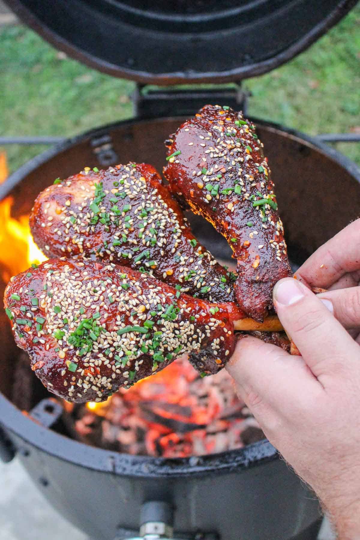 Smoked turkey legs fresh off the smoker with a hot honey glaze, sesame seeds, and chives.