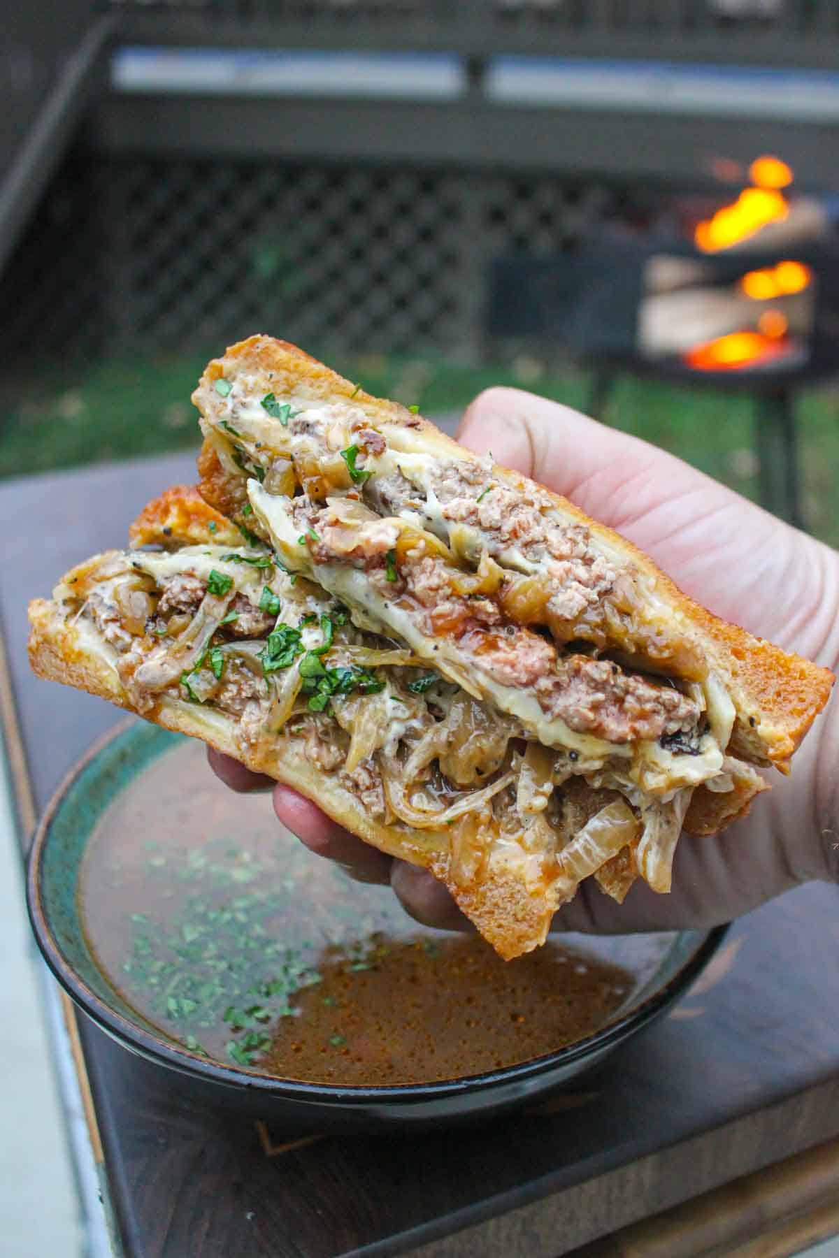 A juicy patty melt with caramelized onions sliced in half.