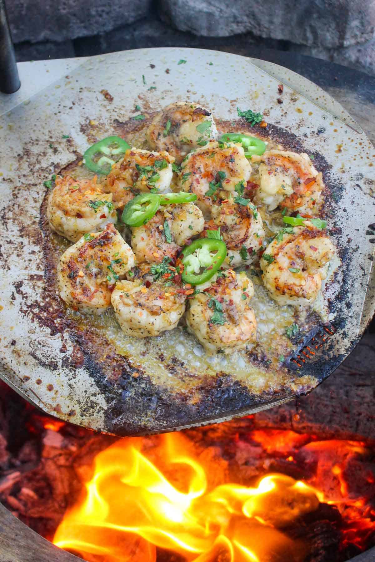 The tequila lime shrimp being roasted on the sear plate over the flames. 