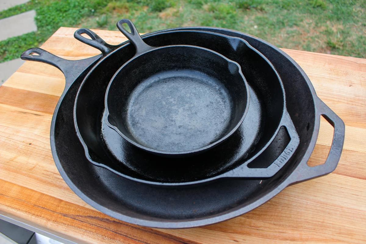 A stack of clean and seasoned cast iron skillets.