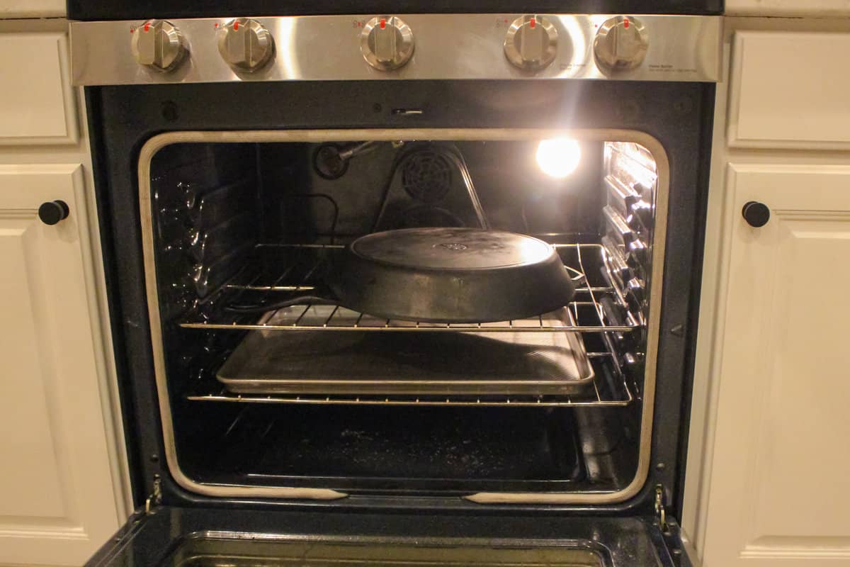 Showing a cast iron pan in the oven ready to be seasoned.