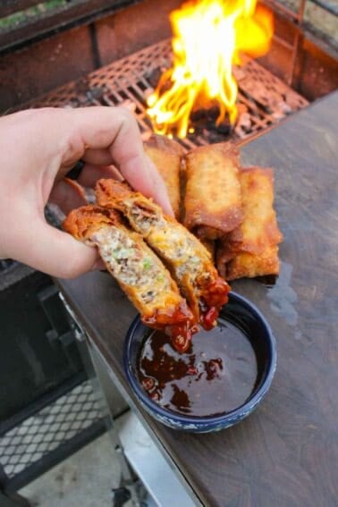 The jalapeño popper egg rolls sliced and dipped in the sauce.