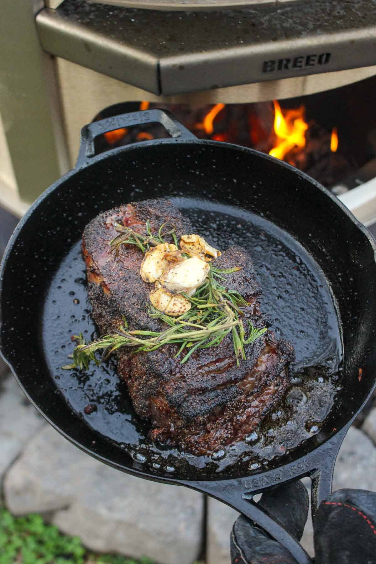 A close up on the steak being pulled from the pizza oven.