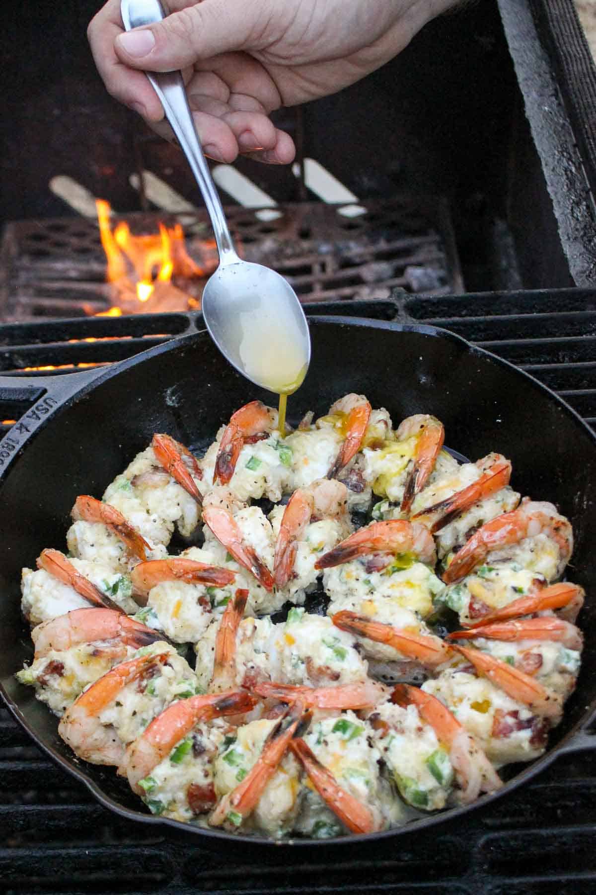 Some melted butter is drizzled over the shrimp halfway through cooking. 
