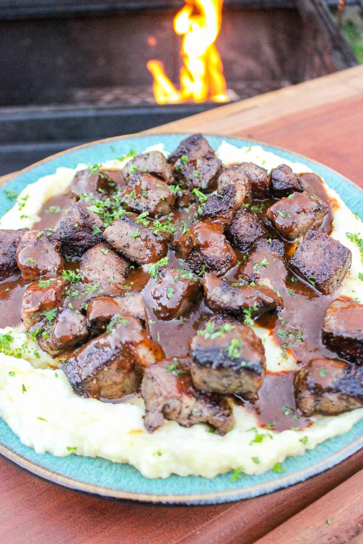 Steak Bites with Mashed Potatoes is served on a plate. 