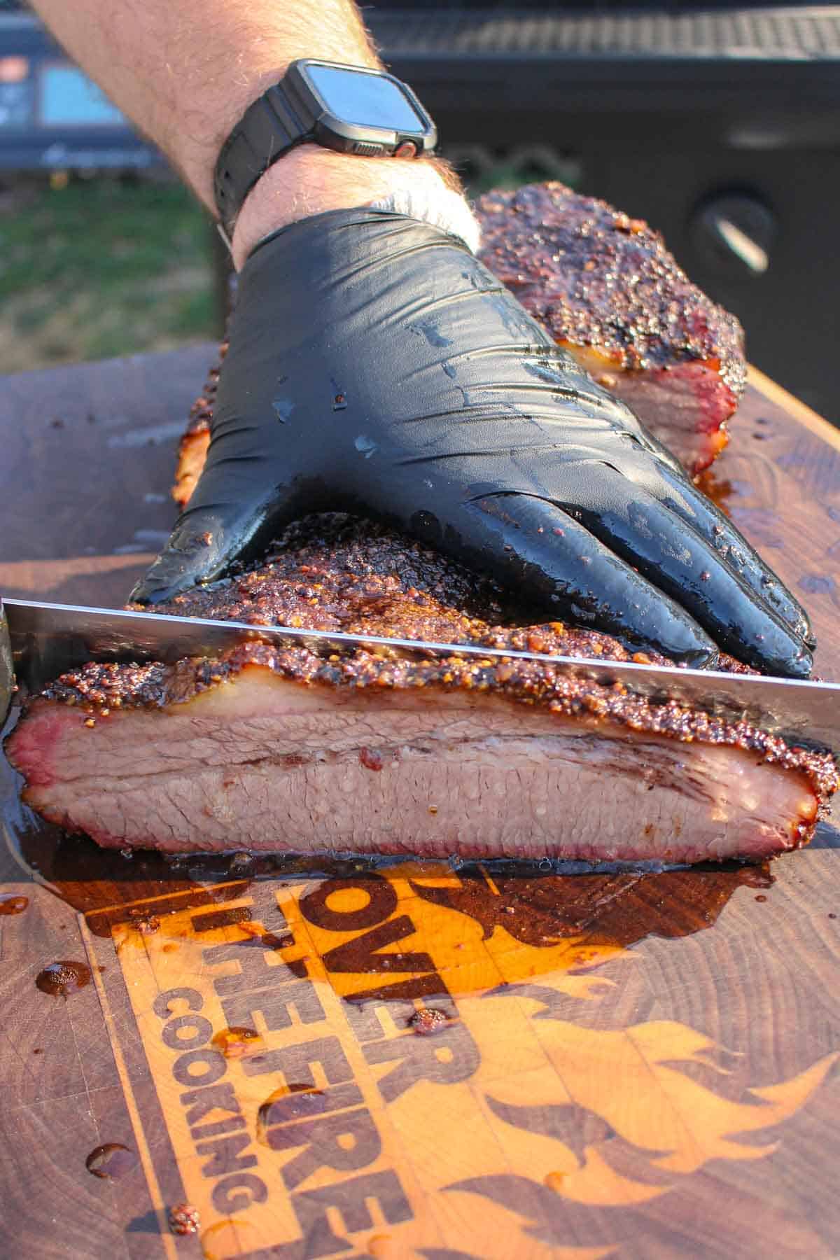 The beef brisket is sliced with a sharp knife. 