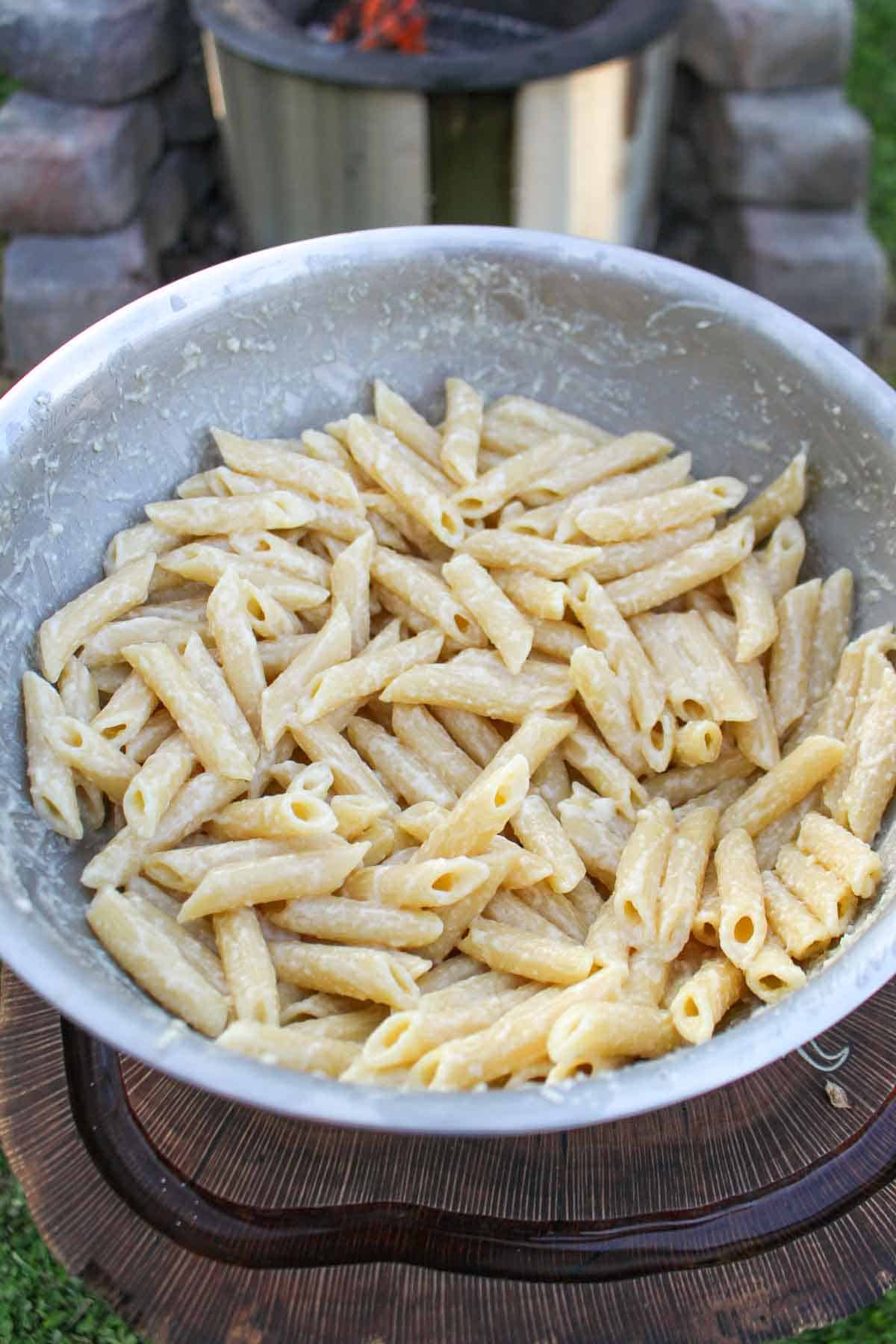 Cooked penne pasta with creamy alfredo sauce.