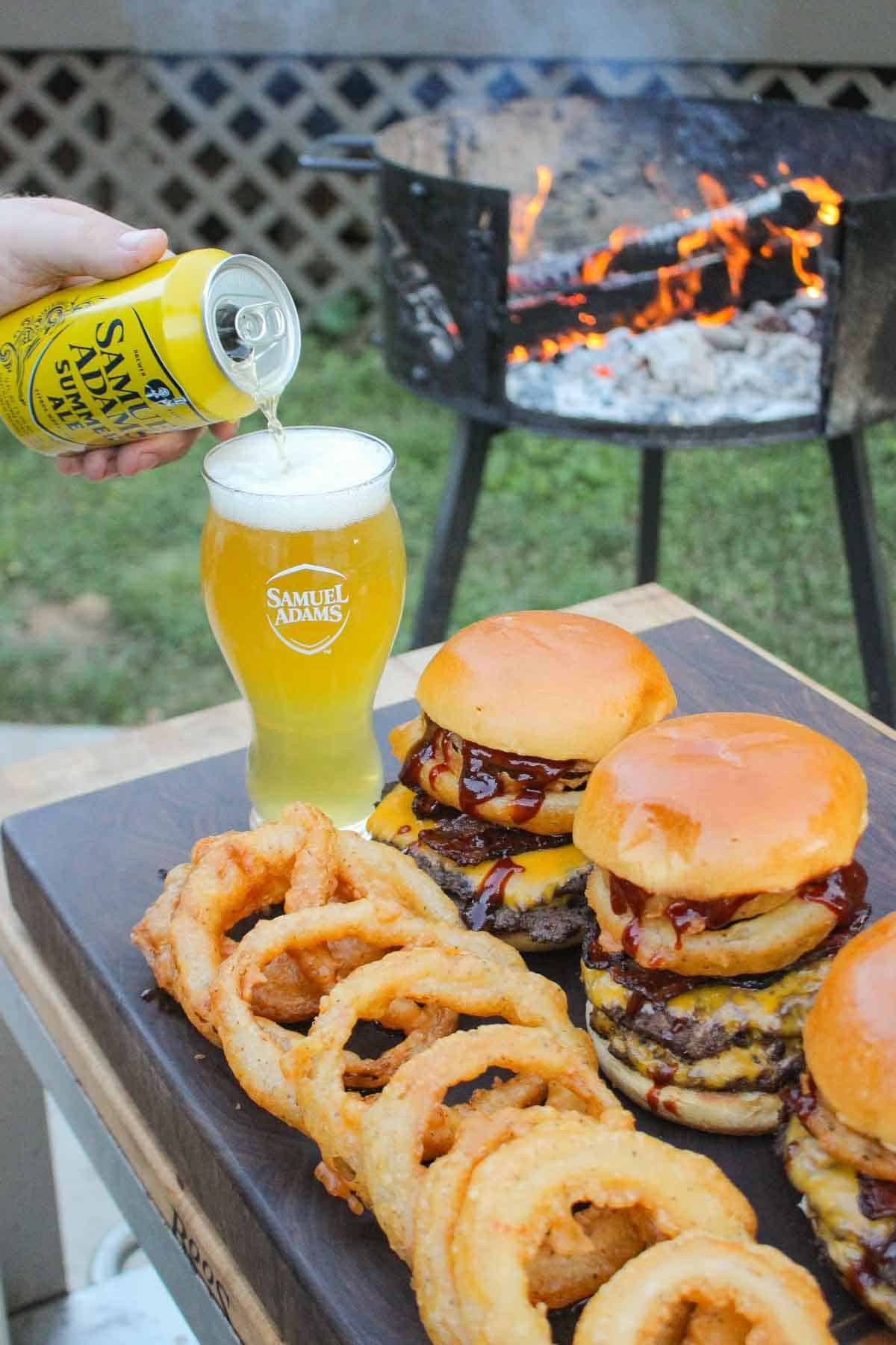 BBQ bacon burgers with onion rings and Samuel Adams Summer Ale.