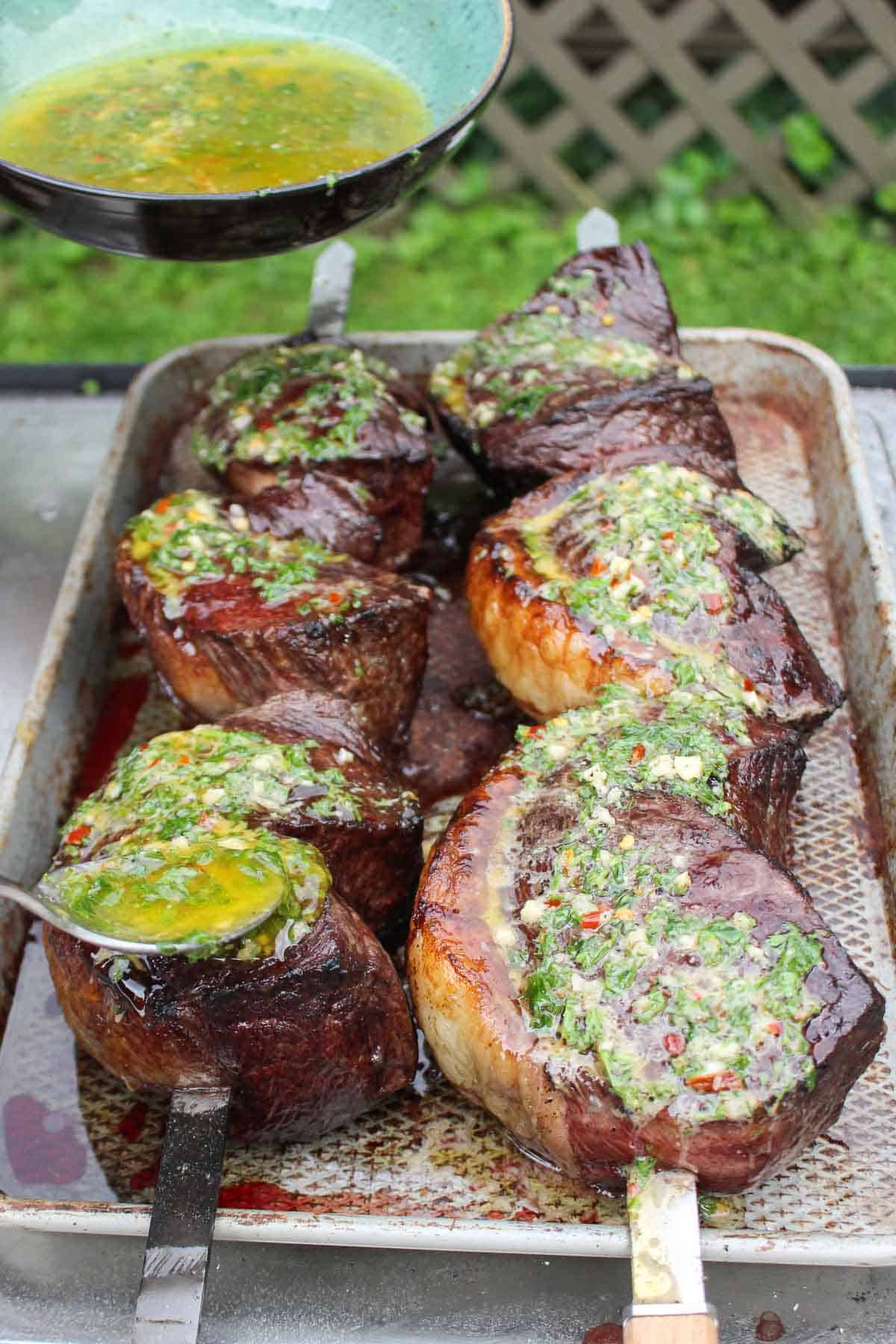 The chimichurri butter is slathered over the picanha steaks after resting. 
