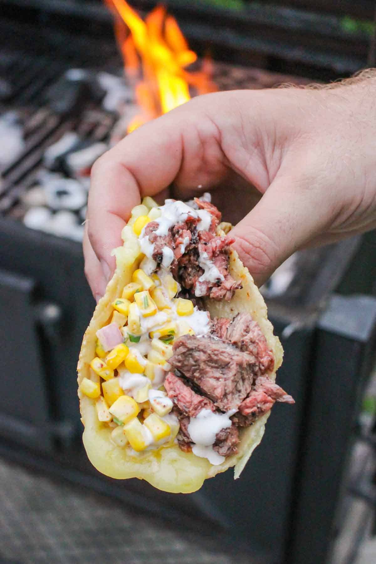 Holding up the grilled steak elote!