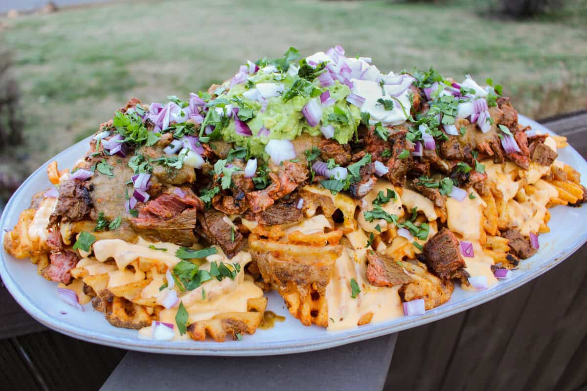 A plate of assembled loaded fries.