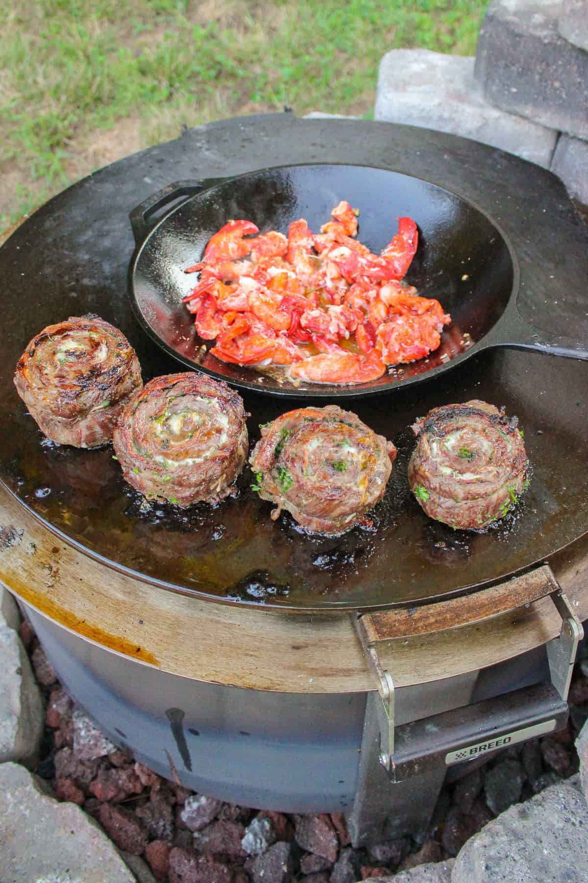 Cooking some steak pinwheels on the grill and lobster in a cast iron wok. 