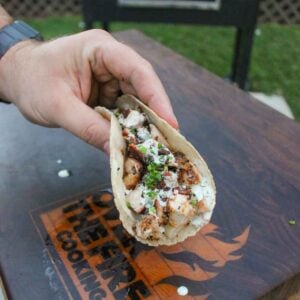 A Chicken Bacon Ranch Taco being held up to the camera.