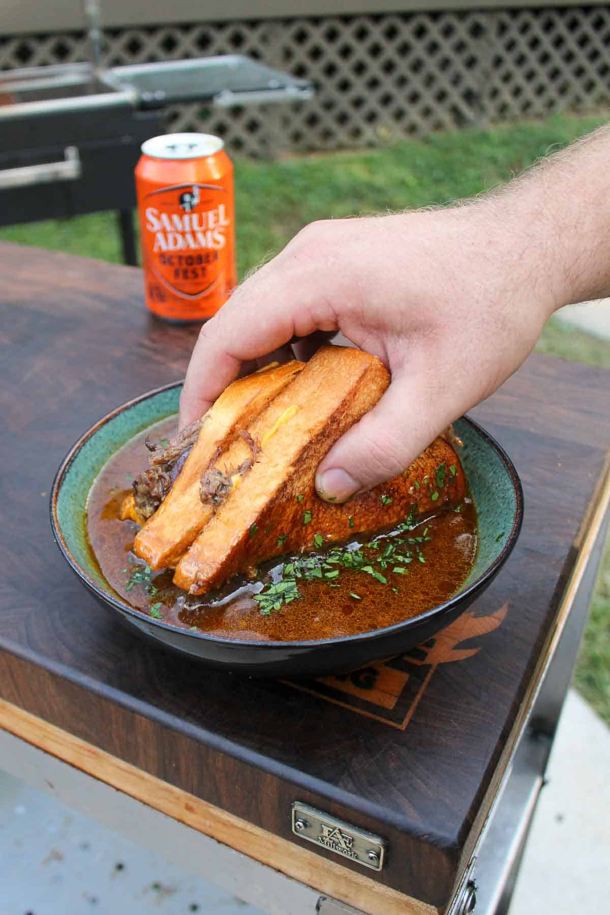 The beef patty melt is dipped in the spicy braising sauce. 