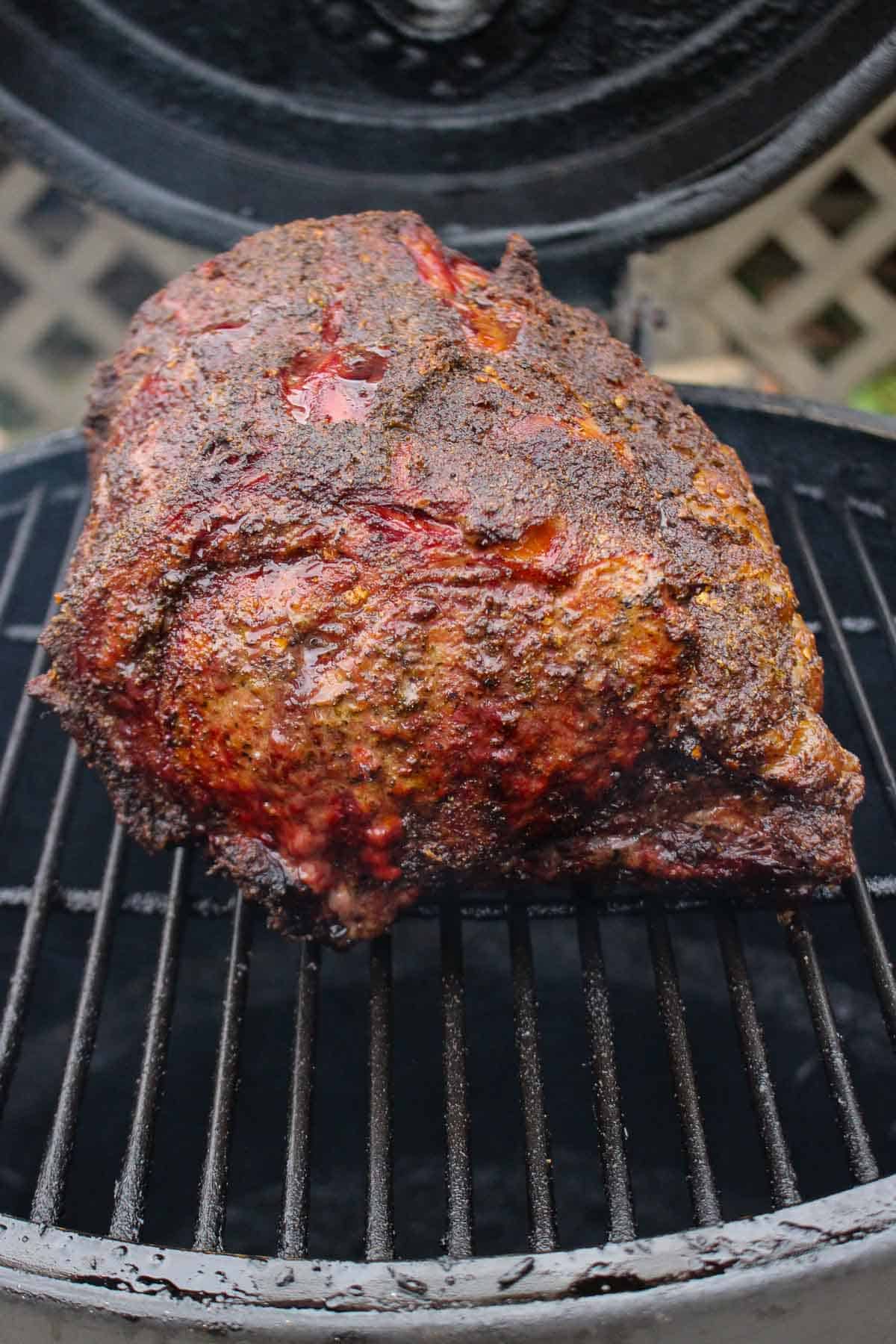 A full prime rib roast smoking on the grill.