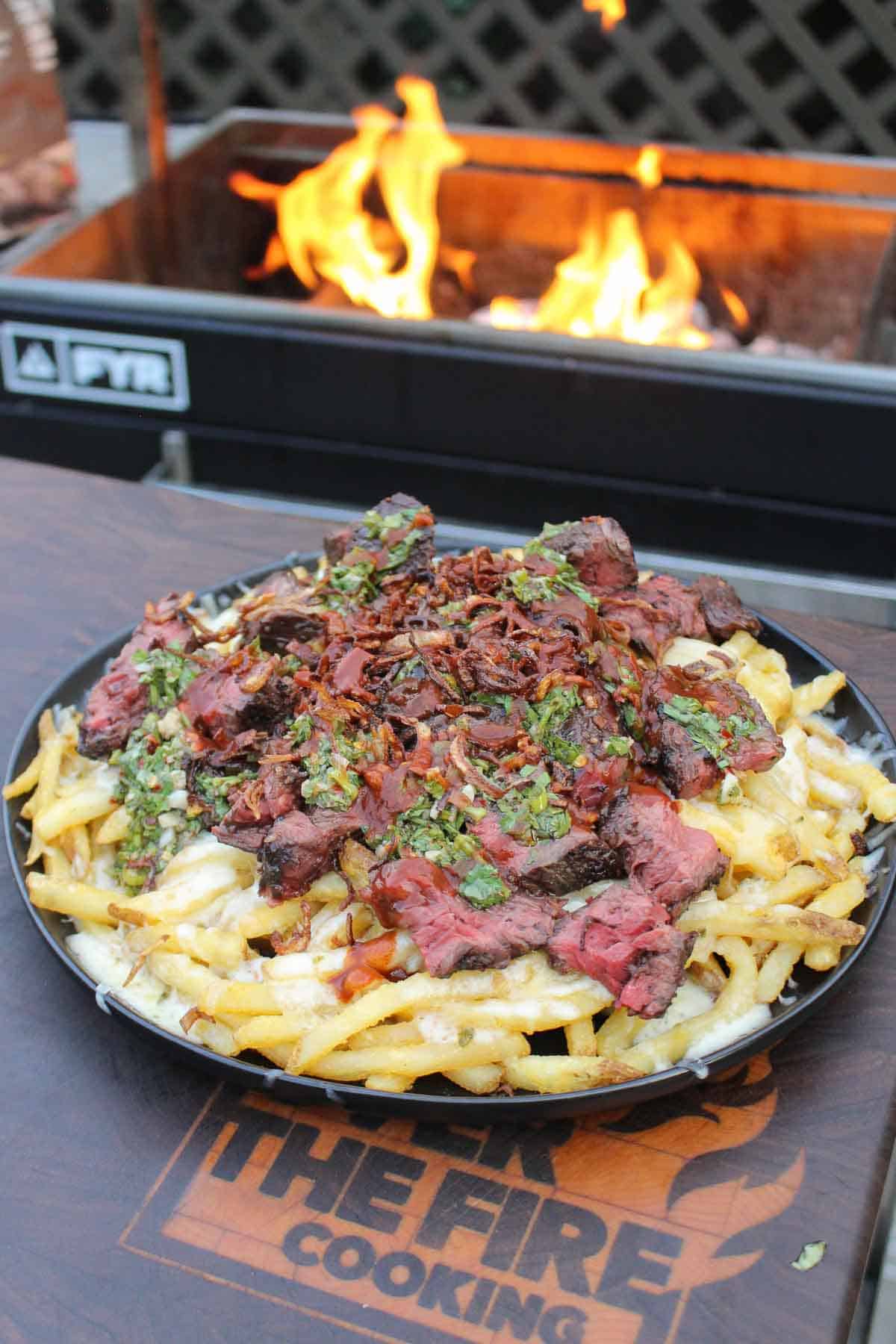 Cheese fries with chimichurri steak are served.