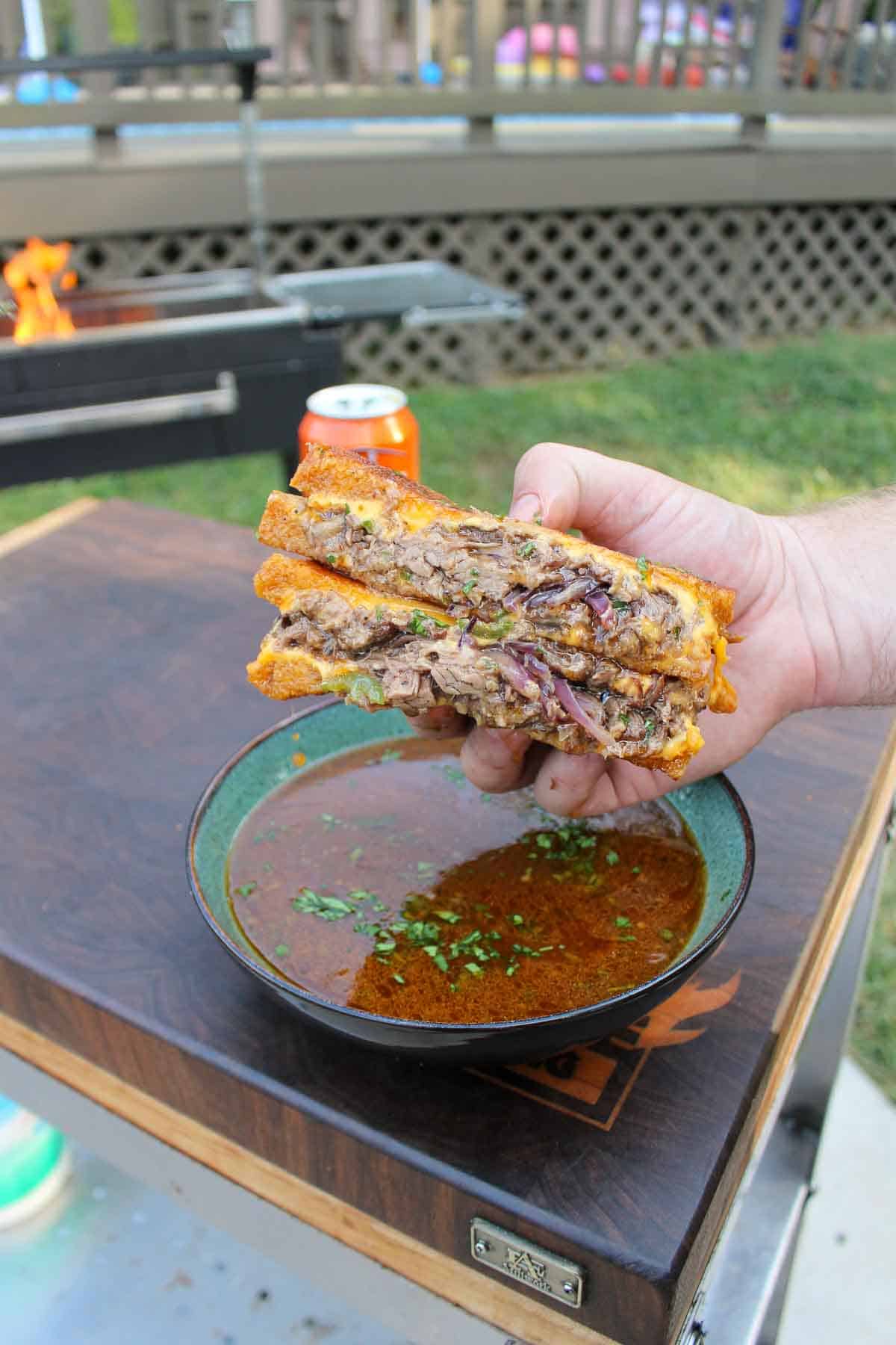 Beer-Braised Beef Melt is sliced in half and served with the braising sauce. 