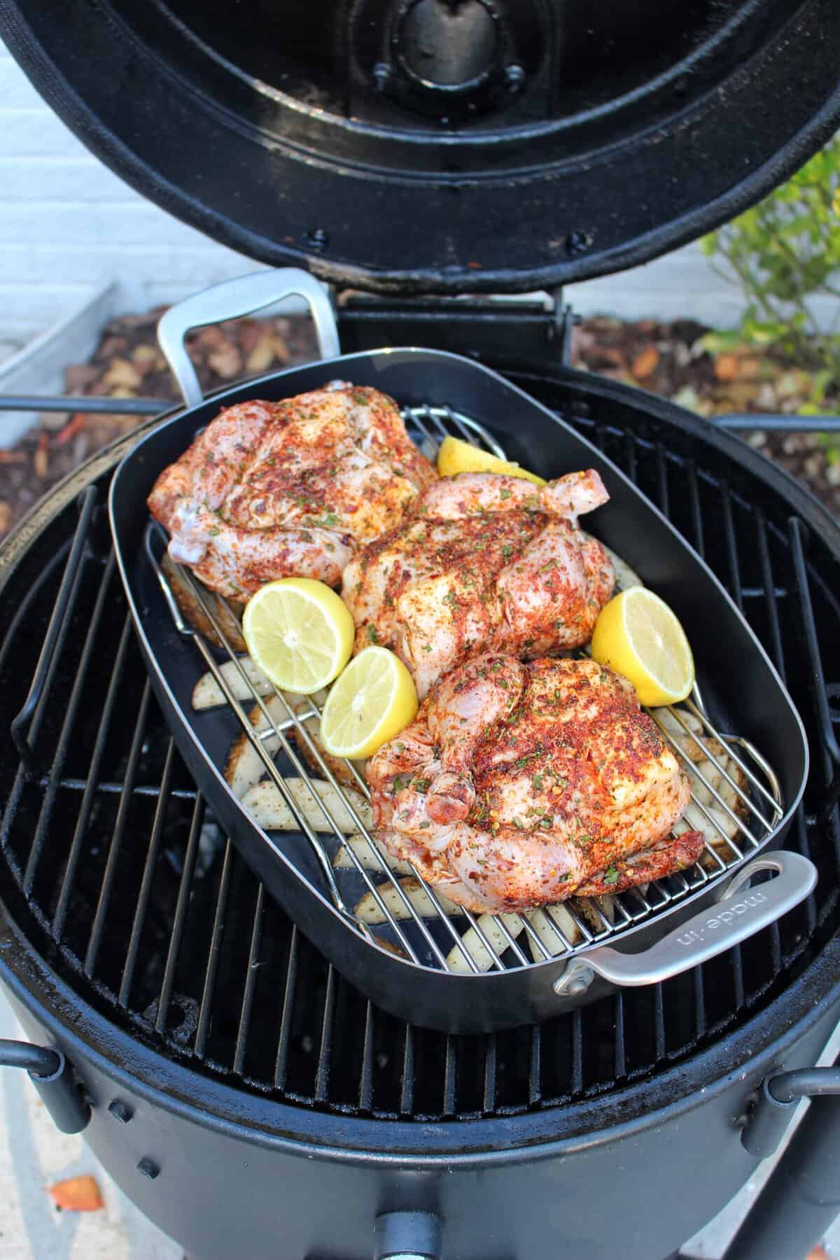 The raw and seasoned Cornish hens in a iron deep dish and set on the smoker to start cooking.