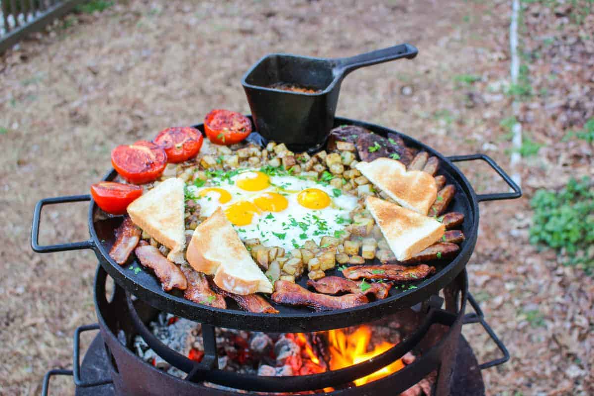 A full plater of meat, eggs, toast, tomatoes and baked beans.