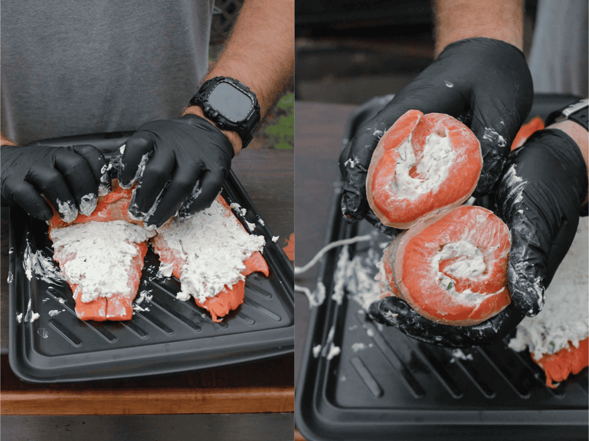 Adding the cream cheese filling to the side of salmon and then wrapping into a pinwheel shape, with gloved hands holding the finished product