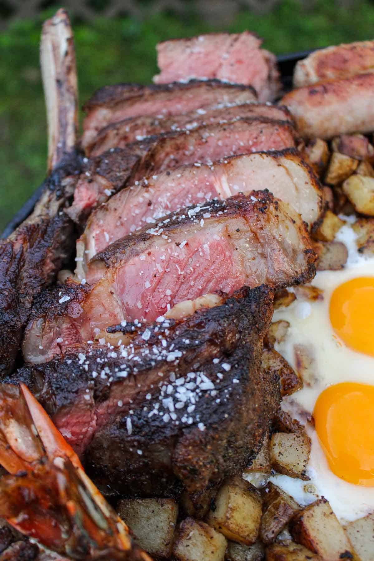 A close up shot of a sliced steak on the breakfast skillet