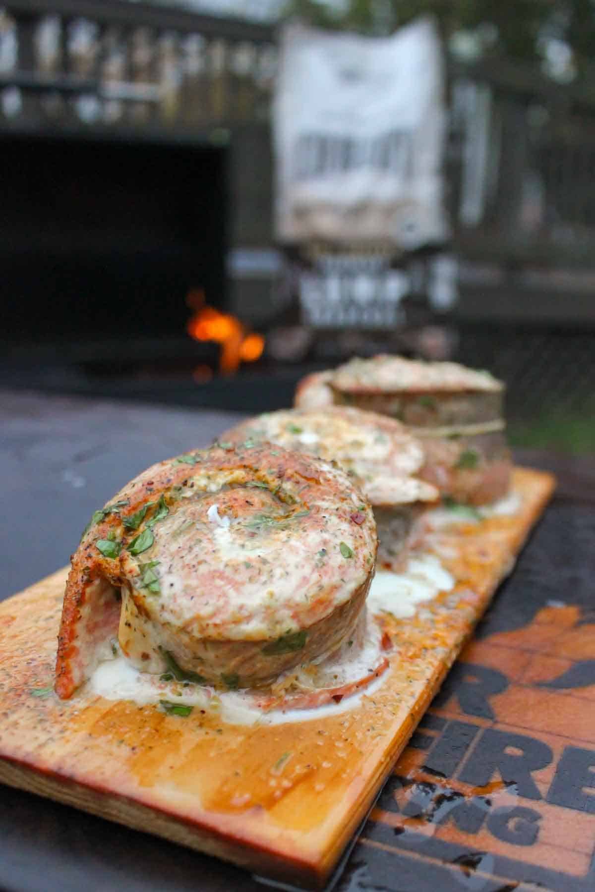 Close up of smoked salmon pinwheels in front of a bag of Cowboy Charcoal