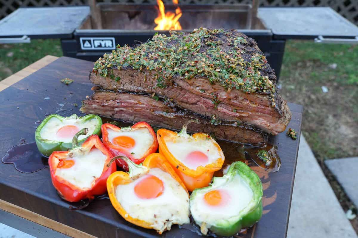 The vacio steak is the perfect size for serving up a satisfying meal to a large crowd. Here's it's sliced on the cutting board with the bell peppers filled with eggs and cheese.