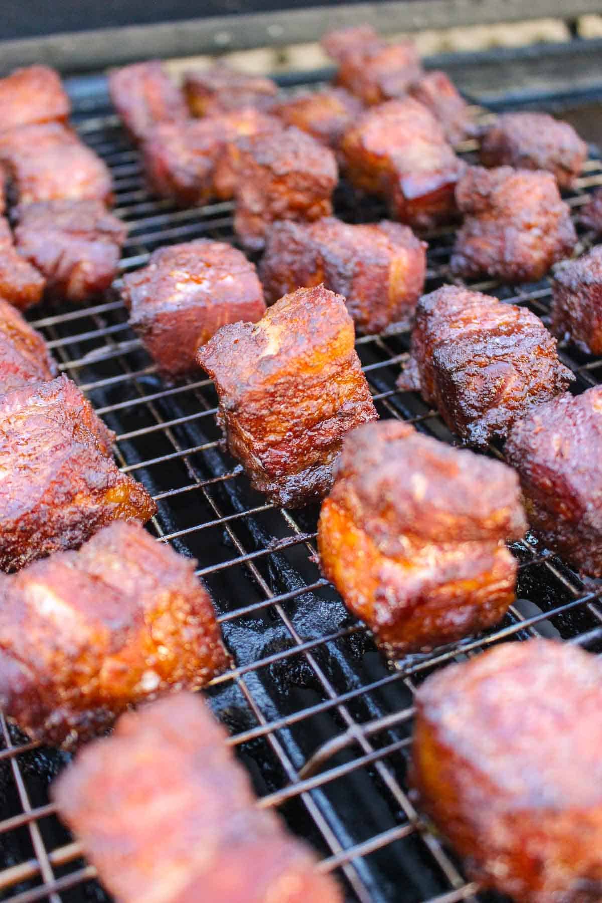 Pork Belly Burnt Ends smoking on a wire rack in the Oklahoma Joe.