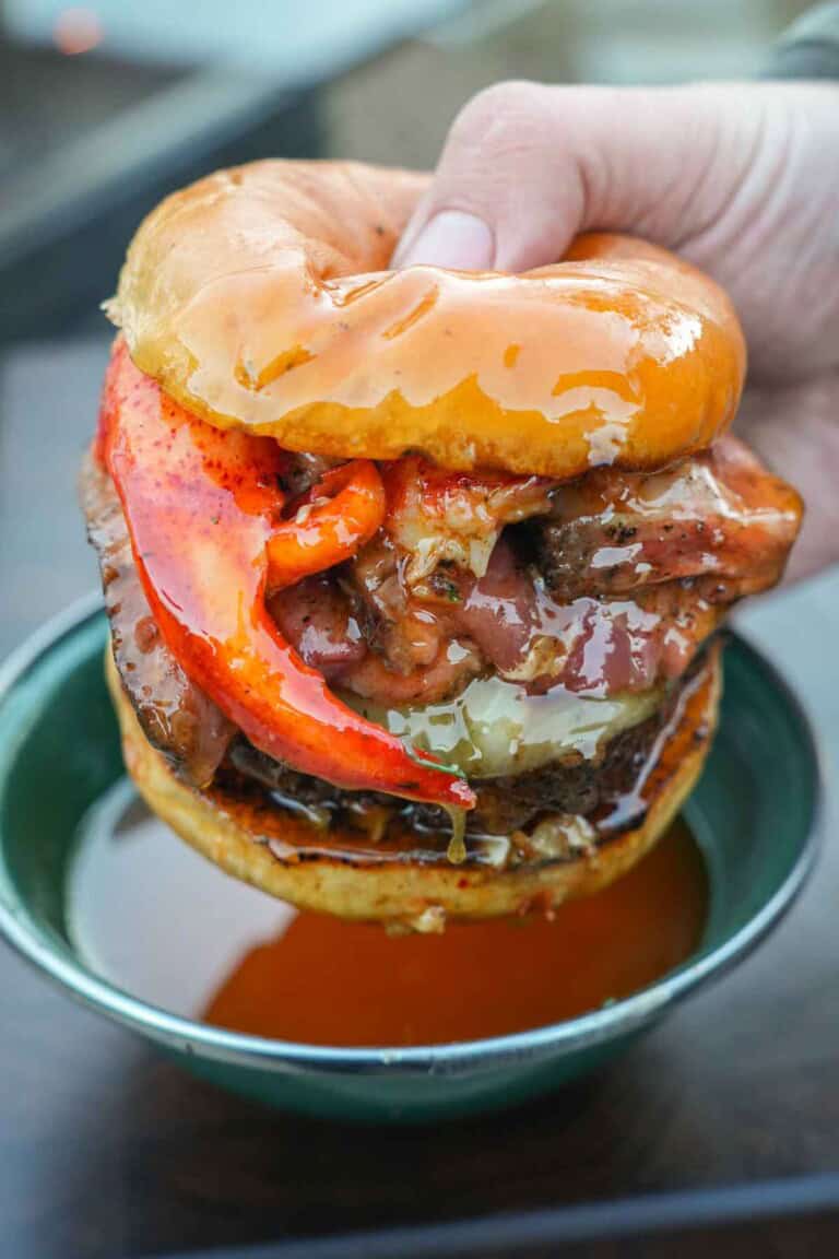 The Surf and Turf Burger is an indulgent masterpiece combining steak, lobster, and a hamburger patty on a toasty bun.