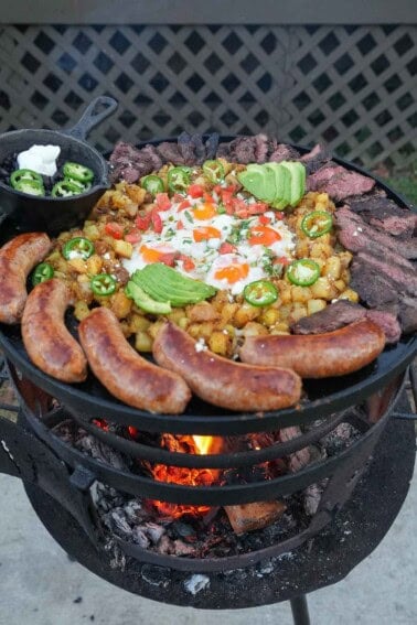 Huevos rancheros, made up of fried eggs, potatoes, chorizo sausage, skirt steak, sliced avocados, jalapeño slices and sour cream