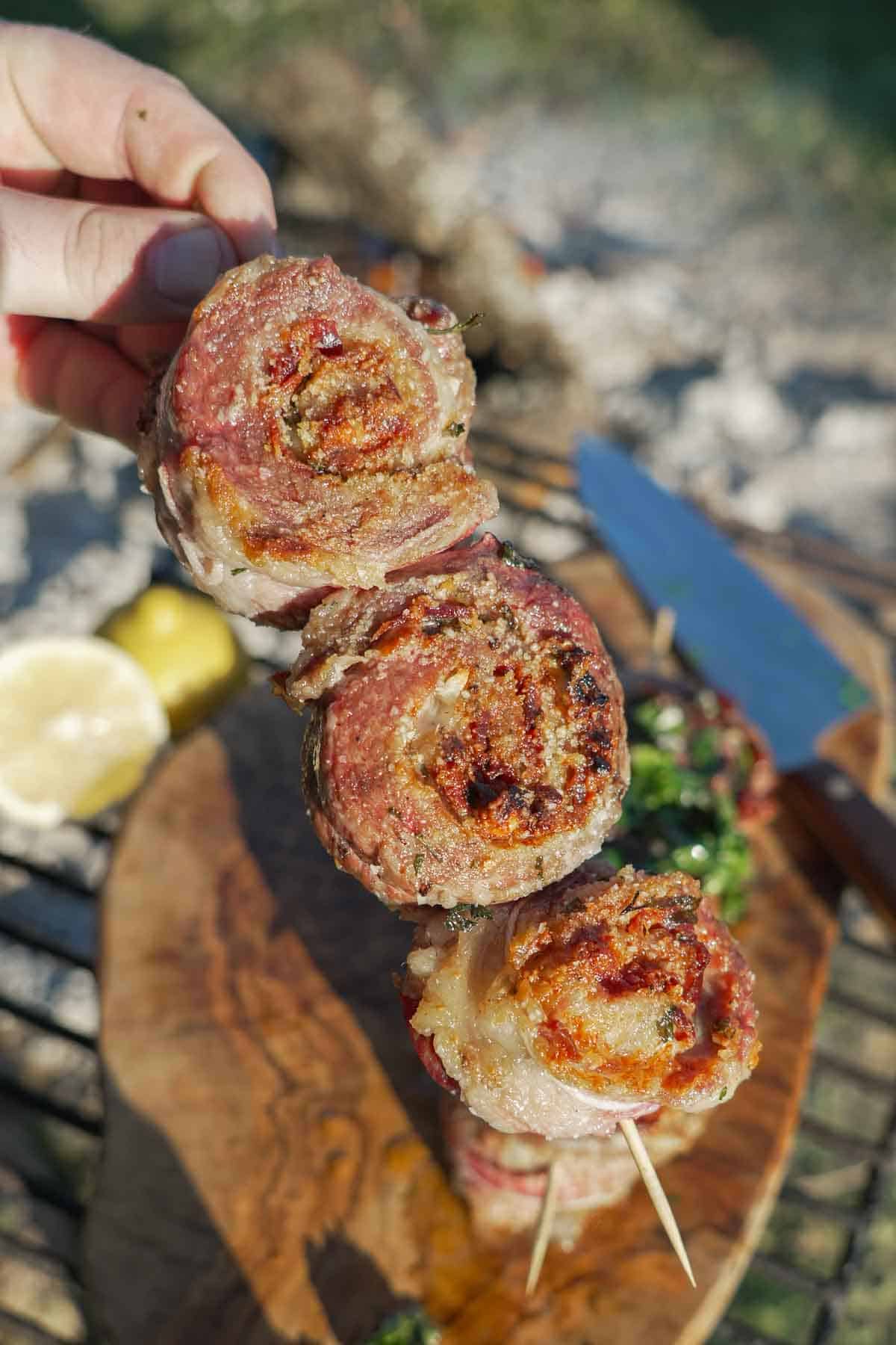 A line of three pork pinwheels, made with secreto steak and stuffed with jamon and Manchego cheese