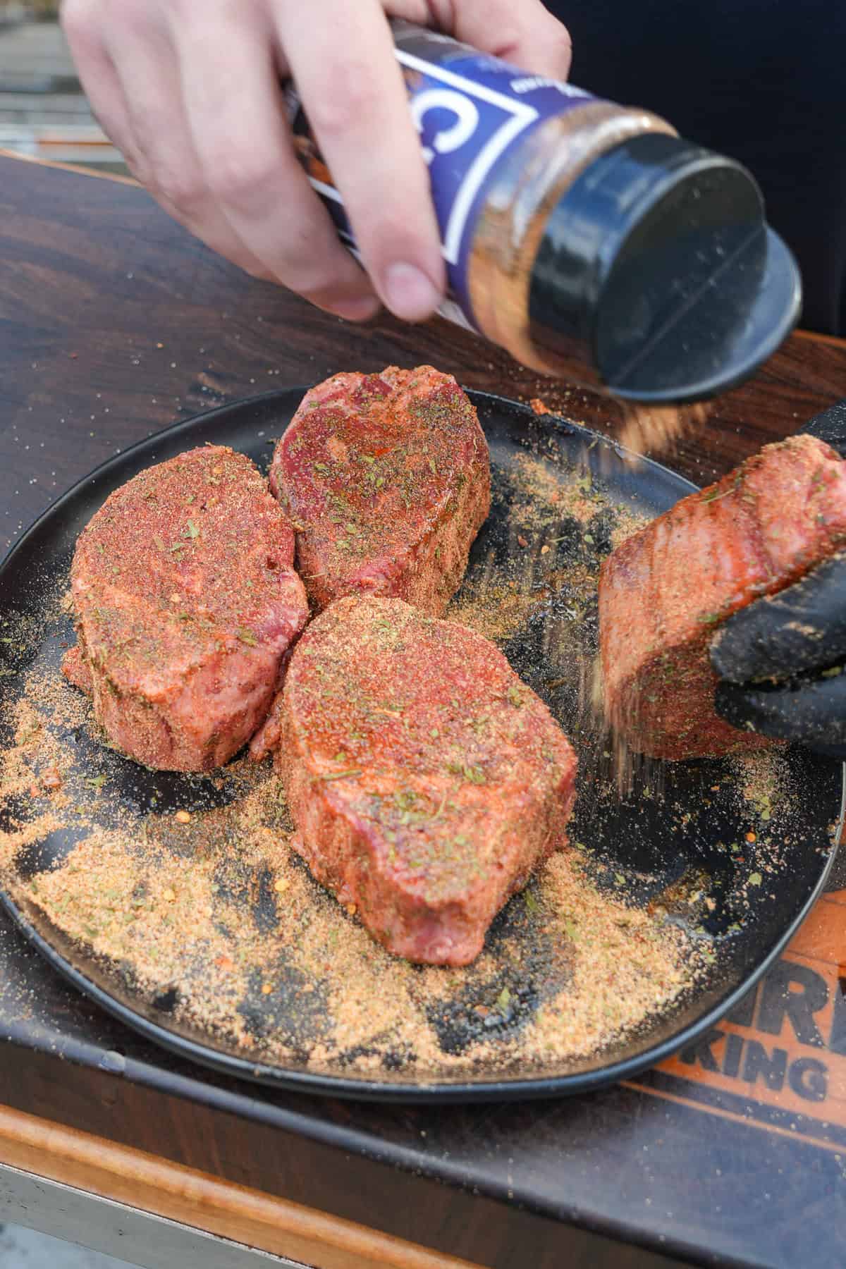 Seasoning the filets on a plate with Cowboy Butter Seasoning