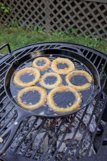 Onion Rings frying in oil over the fire.