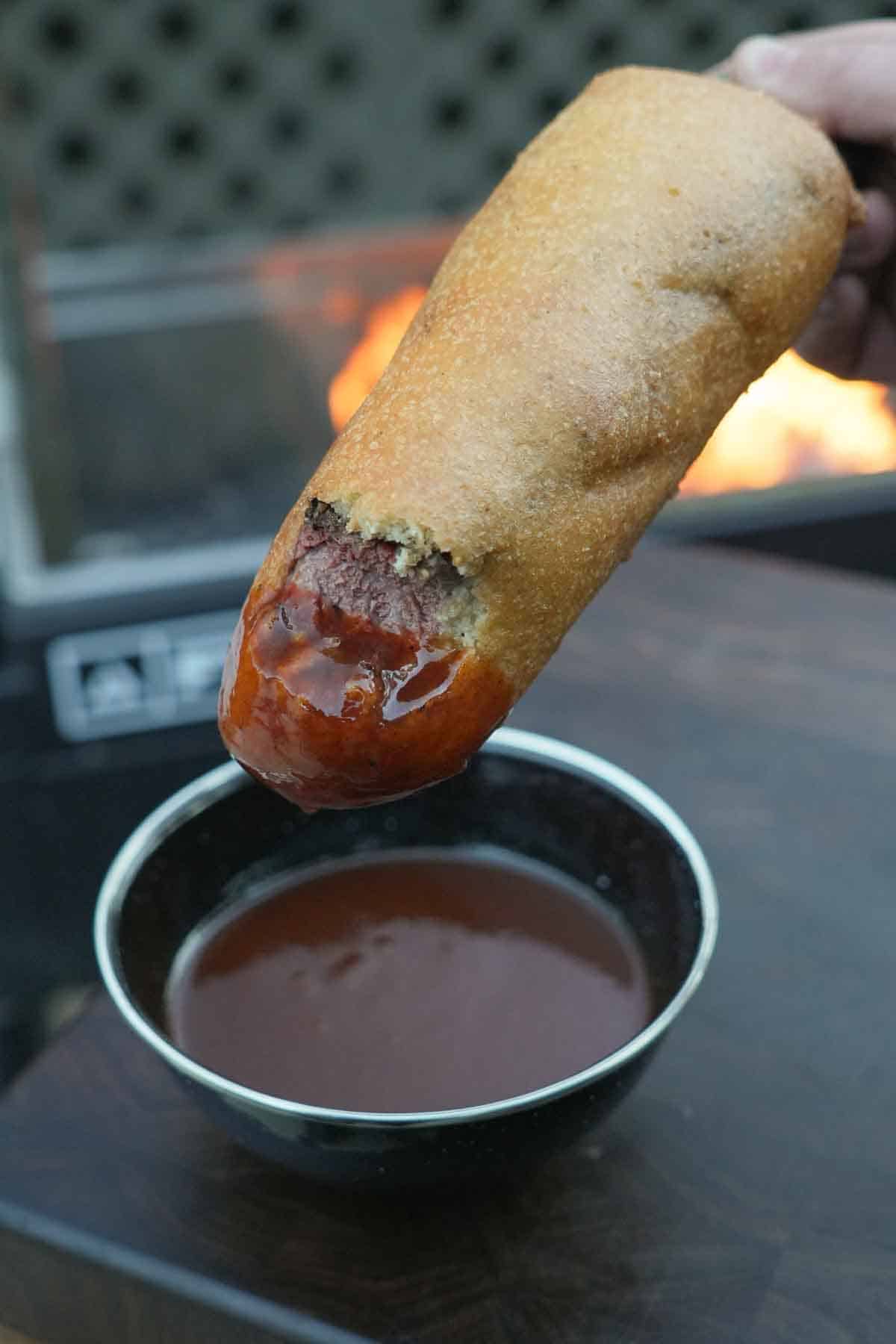 The Beef Rib Corn dog is dipped in some tasty BBQ sauce.