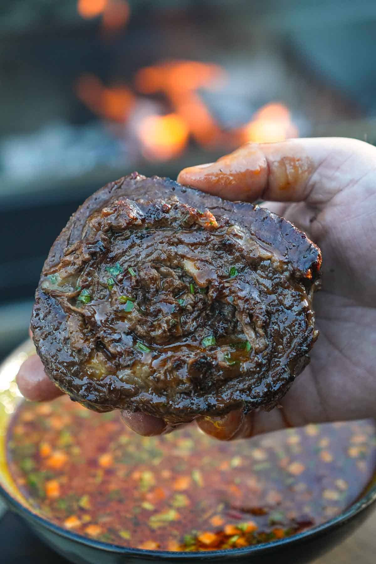 Birria Steak Pinwheels are in Derek's hands, looking perfectly cooked and perfectly ready to eat.