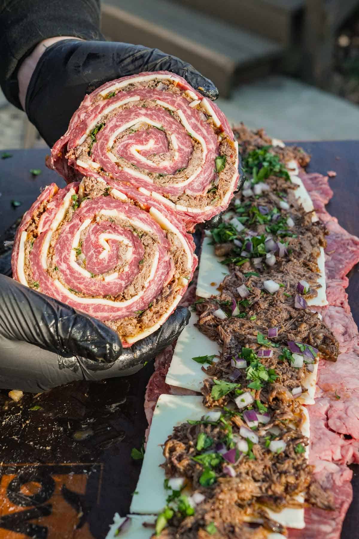 Derek Wolf shows off the inside of one of the pinwheels, stuffed with shredded beef, seasonings, and cheese.