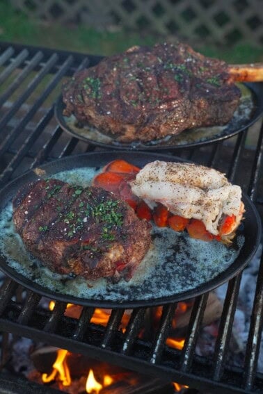 Ruth's Chris steak plated with melted butter, chopped parsley and a cooked lobster tail