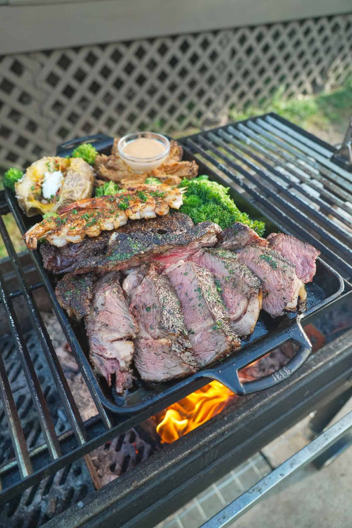 The ribeye is sliced with a sharp knive and presented with grilled shrimp.