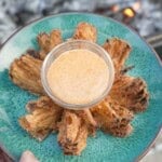 The Bloomin' Onion is served up on a pretty dish with the spicy dipping sauce in a serving bowl in the center.