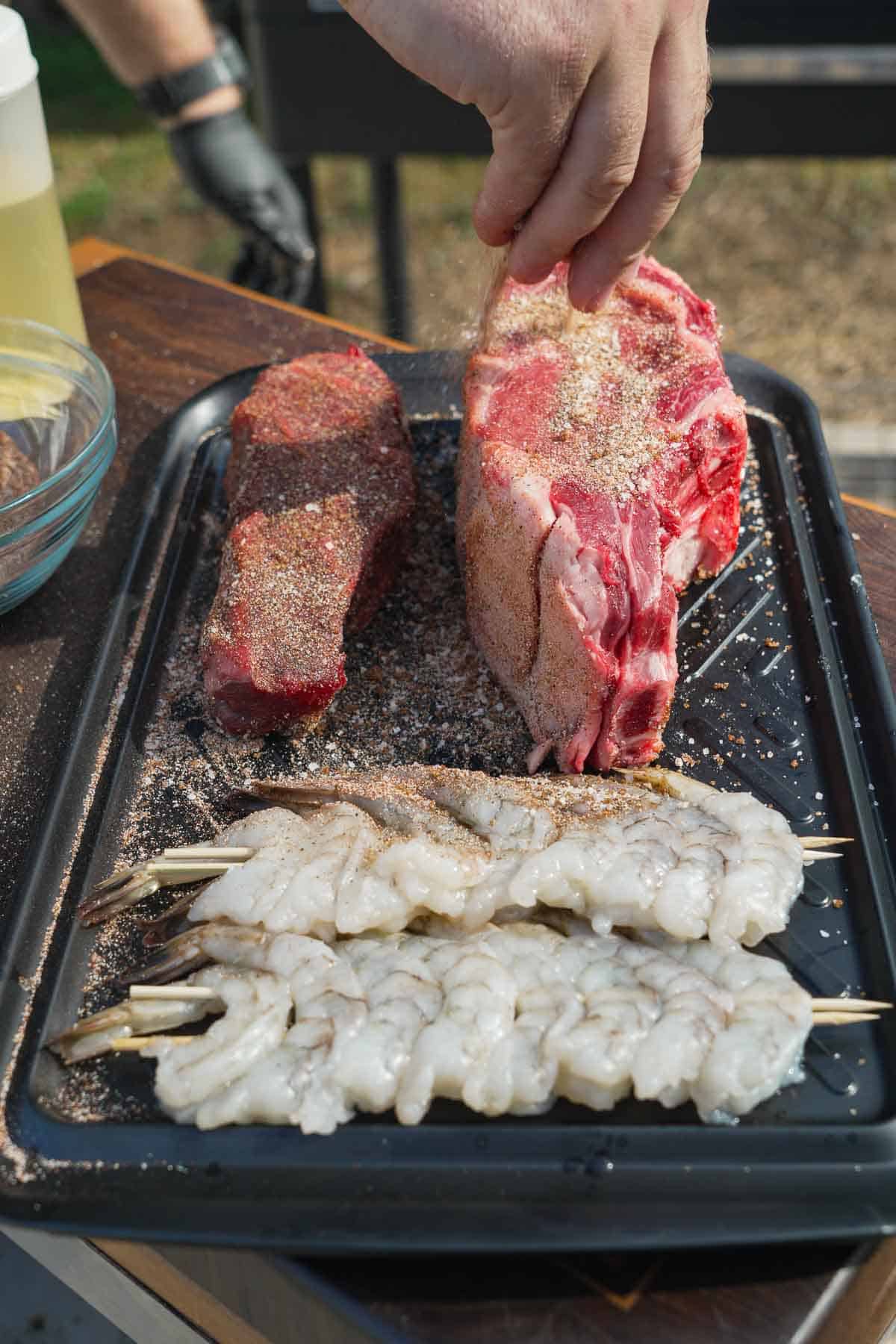 The thick steak is side by side with our grilled shrimp on the FYR Grill.