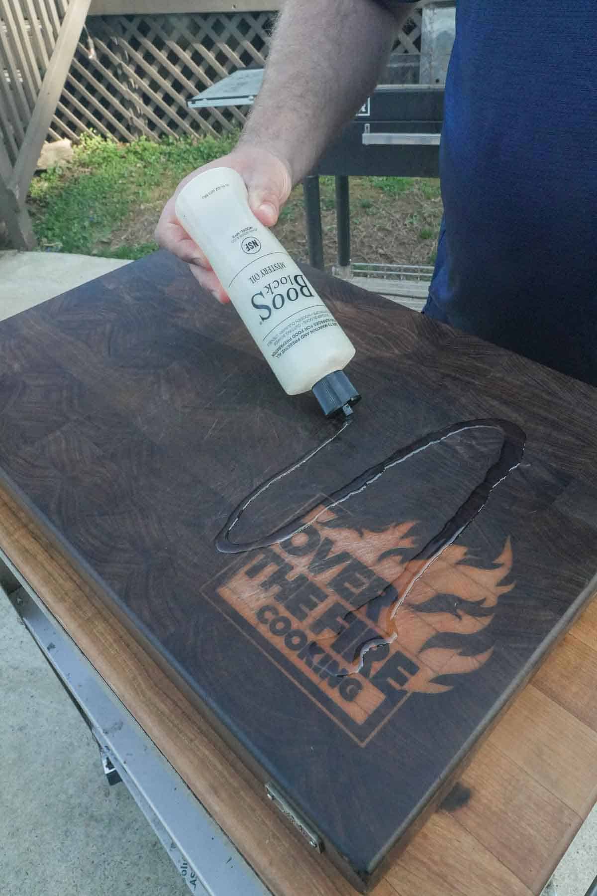 Adding boos block mystery oil to the cutting board.